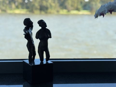 Zwei Skulpturen auf der Fensterbank, dahinter der Rhein